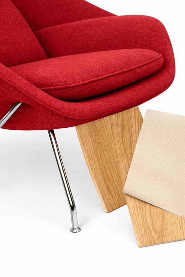 Dettaglio materiali: tessuto rosso, metallo e finiture di design su sfondo bianco.