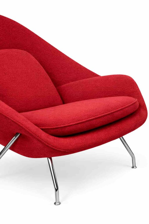 Primo piano della seduta di una poltrona Bauhaus rossa in tessuto, su sfondo bianco.
